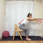 両手を肩の高さで前に伸ばし、後ろの椅子に軽く腰を下ろすスクワットエクササイズ