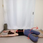 両手を頭上に伸ばした仰向けで両膝を左右交互に倒すストレッチ