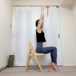 椅子に座り、両手を頭上に伸ばしてかかとを上げ下げするむくみ解消エクササイズ