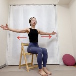 椅子に座り、両腕を左右に開いて胸を広げるストレッチ