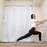 両手を壁につき、右膝を90度に曲げて左足を後ろに大きく引いた腸腰筋ストレッチ
