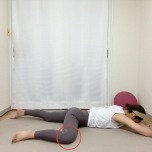 うつ伏せから片膝を90度に曲げて横に出した半分のカエルのポーズ