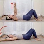 両膝を立てた仰向けから両手を天井に引き上げ、頭上に伸ばした体勢