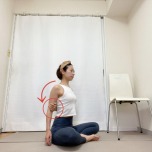 あぐらで座り、右手を背中に回して左肘を掴んだ体勢