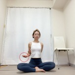 手のひらを上に向けて左肘を曲げ、右手を背中に回して左肘を掴んだあぐらの姿勢