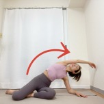 右脚を前にした横座りから、右肘を床につき、左手を引き上げて上体を右に倒す左体側を伸ばすストレッチ