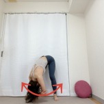 肘を抱え、立って前屈した体勢で上体を左右に揺らすストレッチ