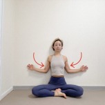 壁を背にしてあぐらで座り、両腕を壁に沿わせながら肘を曲げて体側に寄せた体勢