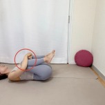 仰向けになり、脛を抱えて膝を胸に寄せるストレッチ