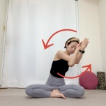 あぐらで座り、左を上にしたイーグルポーズの腕で、左回りに胸の前で円を描くストレッチ