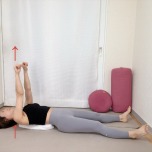 丸めたバスタオルを肩甲骨の下にセットした仰向けから肩甲骨を浮かせて両手を天井に伸ばした体勢