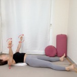 丸めたバスタオルを肩甲骨の下にセットした仰向けから両手を天井に伸ばしたまま肩甲骨をタオルに沈め、軽く握った拳で小さな円を描く、肩甲骨ほぐし