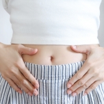 お腹に両手をあてる人
