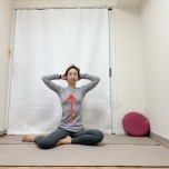 頭の後ろで手を組んで背筋を伸ばし、膝下を左に流した横座りの体勢