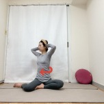 頭の後ろで手を組んで膝下を左に流した横座りから上体を左に捻って脇腹を縮めるエクササイズ