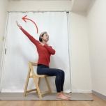 椅子に座り、右手を左鎖骨下へ、左手を斜め上に伸ばす小胸筋ストレッチ