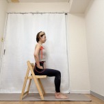 両手を鼠径部に添え、背筋を伸ばして椅子に座った体勢