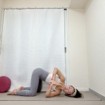 四つ這いで左脇の下から右腕を通したキャットツイストポーズで胸の前で両手を合わせたストレッチエクササイズ