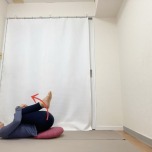 お尻の下にクッションを敷いて両膝を胸に抱えた仰向けの体勢