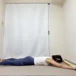 タオルの端を持ち、両手を頭の上に伸ばしたうつ伏せの体勢
