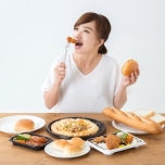 脂質多い食事を食べる女性