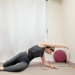 膝を立てて座っり、右肘を後ろの床に下して左手を引き上げ、両膝を右に倒して後ろを振り返って左腰から体側を伸ばすストレッチ