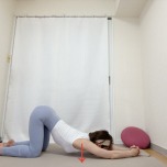 両手を組んで肘をついた四つ這いから顎を床に下し、脇・胸を開くストレッチ