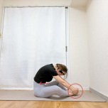 両手でつま先を掴んだがっせきからお腹を引き込んで骨盤を後ろに倒して背中を丸めて座った体勢