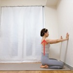 壁の前で正座で座り、両手を壁につき、背筋を伸ばした体勢