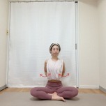 あぐらで座り、肘を曲げて軽く握った手を腰に添え、肘を後ろに引いて肩甲骨を寄せた体勢