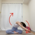 あぐらで座り、両手を組んで頭上に府引き上げて上体を回す背骨のストレッチ