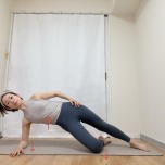 肩の下の床に左肘をつき、左膝を曲げて右足を伸ばした横向きの体勢からお尻を引き上げたやさしいサイドプランク