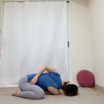 膝を広めに開き、左腕を右脇に通し、右手を背中に回したツイストチャイルドポーズ