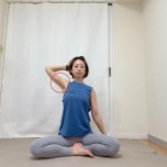 左手を後頭部に添えて脇を開き、あぐらで座った体勢