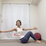 両膝を立て、上体を少し後ろに傾けて座り、右手を前、左手を後ろに伸ばしたツイストエクササイズ