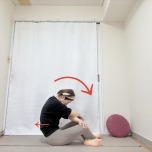両手を体の前でクロスして膝を掴み、背中を丸めるように重心を後ろに引いたあぐらの体勢