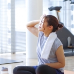 運動後にタオルで汗を拭く人
