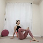 両手を後ろの床に着き、左を上にして脚で数字の4の形を作って座った体勢