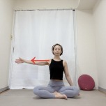 あぐらで座り、左腕を肩の高さで横に伸ばした体勢
