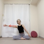あぐらで座り、左腕を横に伸ばし、上体を左へスライドさせて体側、脇腹を伸ばした体勢