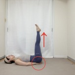 手のひらをお尻の下に敷き、両足を天井に伸ばした仰向けの体勢