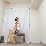 両手を腰に添え、背筋を伸ばして椅子に座った体勢